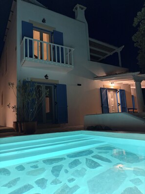 Un bâtiment à deux étages avec une piscine en premier plan.