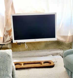A television on a stand with a wooden tray in front of it. - 34ft Mobile Home Near Yale U (New Haven)
