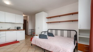Une chambre avec un lit, une armoire et un coin cuisine.