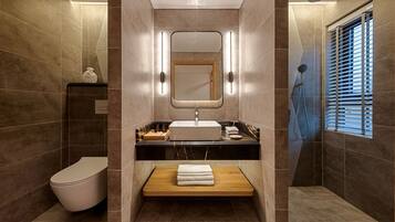 A modern bathroom with a toilet, sink, and shower.