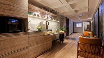 A modern kitchen with a built-in coffee machine, a fruit bowl, and a breakfast bar.