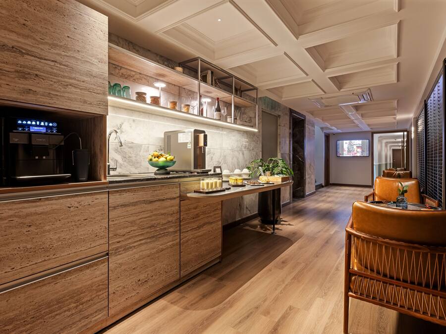 A modern kitchen with a built-in coffee machine, a fruit bowl, and a breakfast bar.