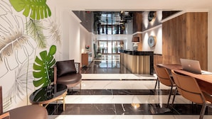 A modern interior with a dining area, a seating area, and a kitchen visible in the background.