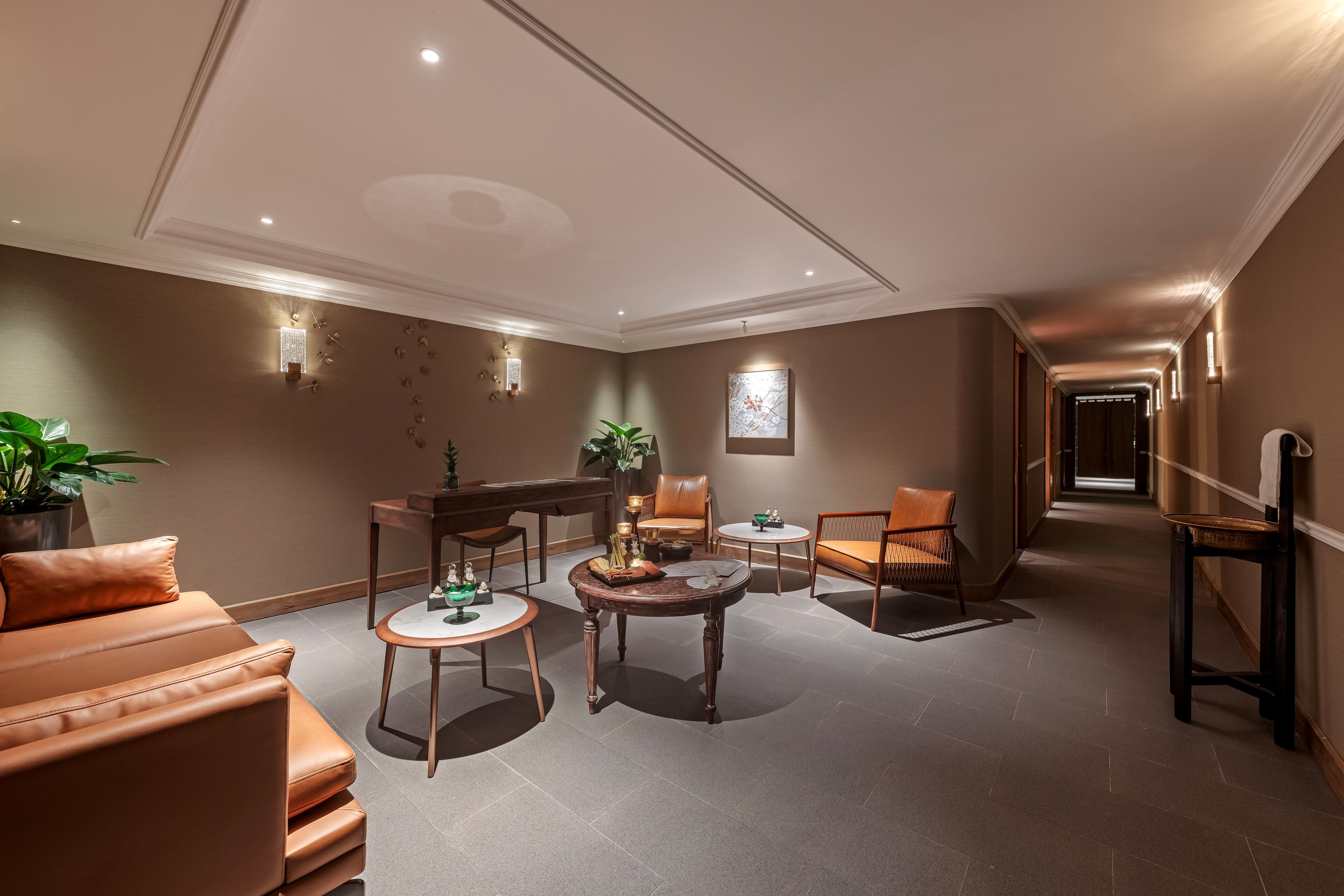 A modern lounge area with leather sofas, a piano, and a coffee table.