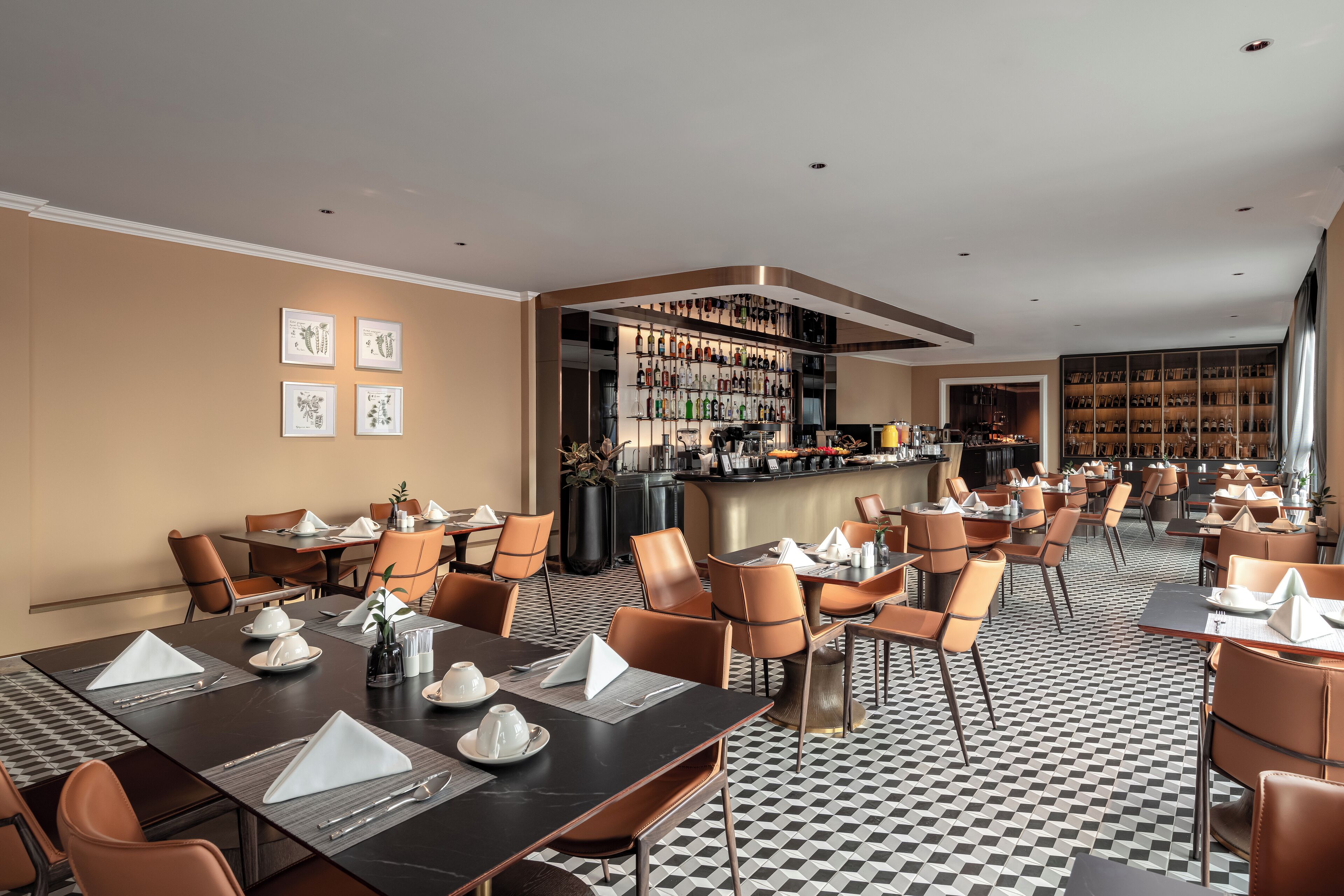 A hotel dining area with tables set for guests, a bar area with a variety of bottles, and a large wine collection on shelves.