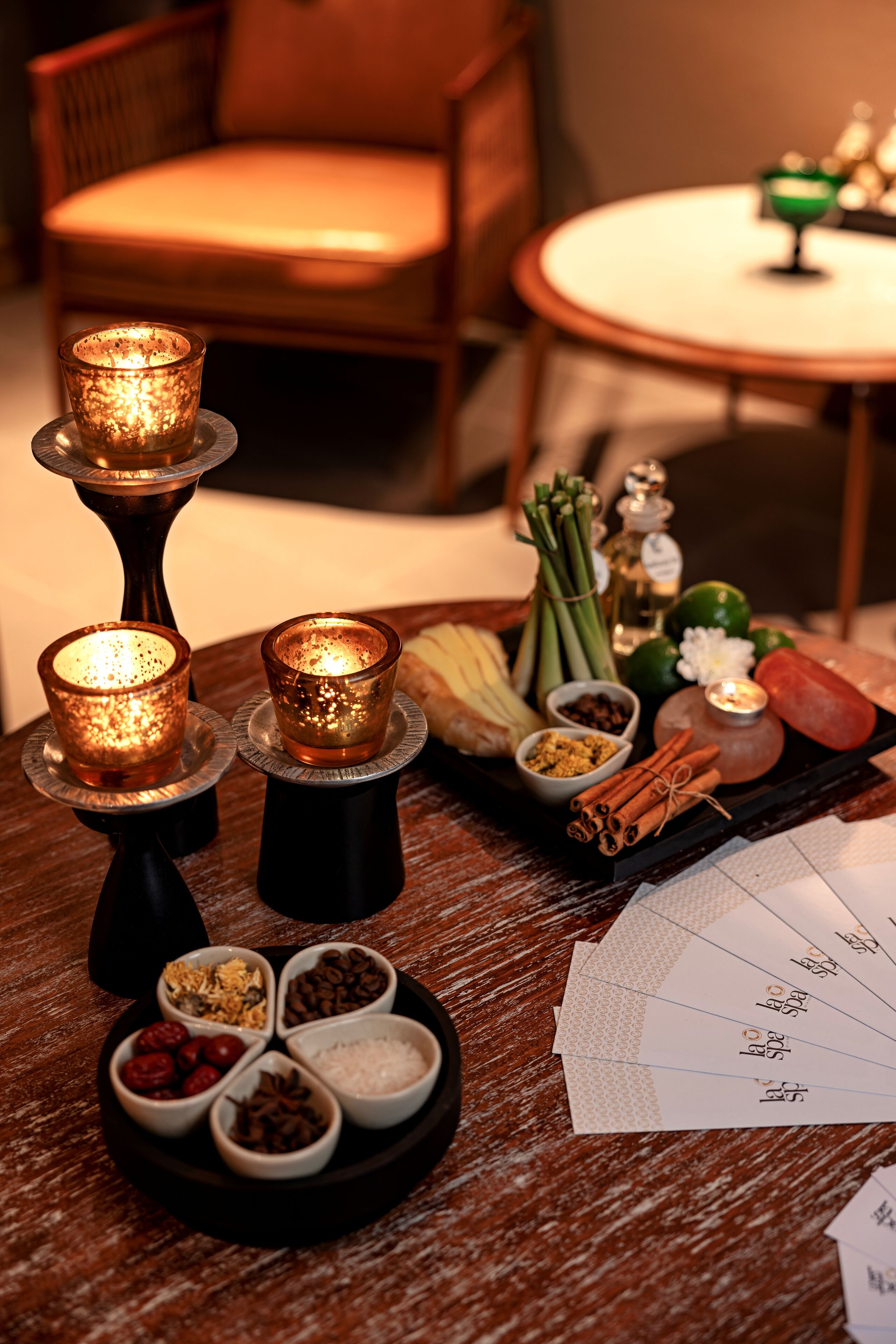 Una mesa con velas, especias y una bandeja de comida.
