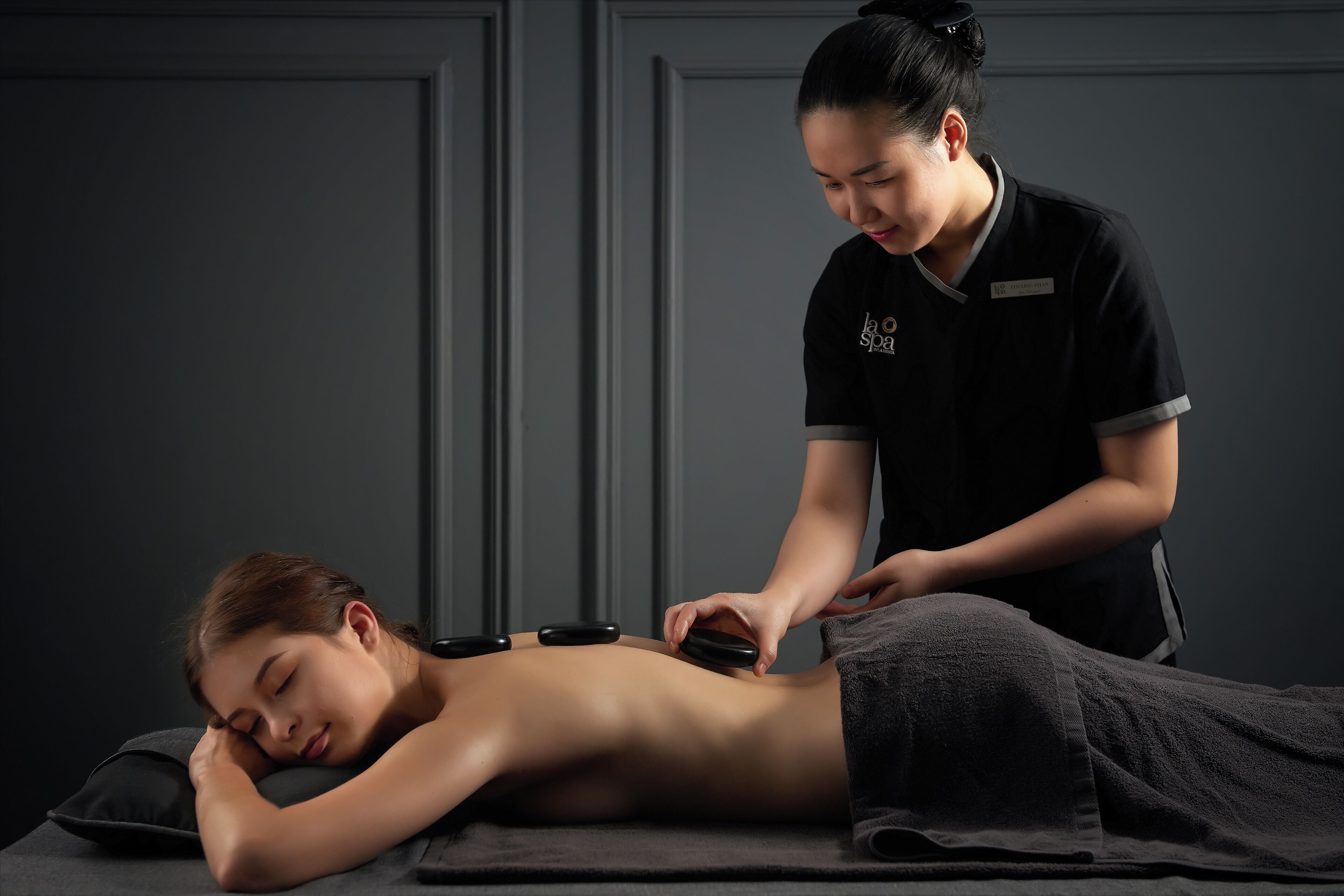 Een massage in een spa: een cliënt ligt op een massagetafel terwijl een therapeut een massageapparaat gebruikt.