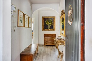 Un couloir avec un banc en bois, une commode et un tableau encadré accroché au mur.