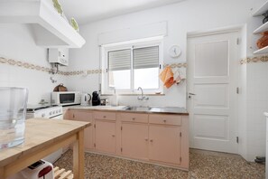 A kitchen with a microwave, stove, sink, and cabinets.