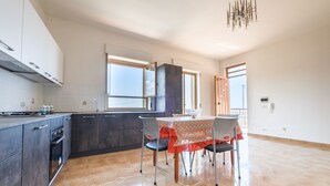 Una cucina moderna con mobili scuri, un fornello a gas e un'area pranzo con tavolo e sedie.