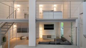 A modern interior with a staircase, a sofa, a TV, and a white cabinet. - Holiday Apartment "Alison's Loft" with A/C & Wi-Fi (Alicante)