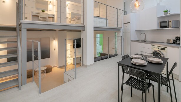 A modern interior with a dining area, kitchen, and a staircase leading to an upper level. - Holiday Apartment "Alison's Loft" with A/C & Wi-Fi (Alicante)