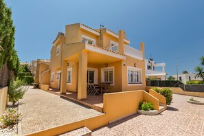 A multi-story residential building with a balcony, outdoor seating, and a tiled patio area. - Holiday Home 'La Cala' with Sea View, Wi-Fi and Air Conditioning (Cabo de palos)