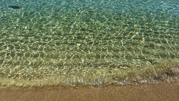 A clear view of a beach with shallow water and a distant sailboat. - Vacation Home "San Lorenzo" with Private Terrace, Private Garden and A/C (San Lorenzo)