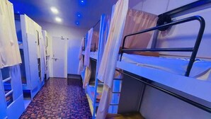 A corridor with bunk beds, a patterned floor, and a door at the end. - Golden Star Dormitory (Mumbai)