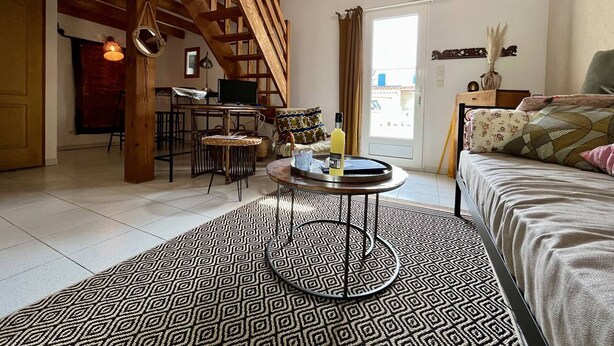 A cozy living room with a wooden staircase, a dining area, and a large window. - House for 4 with Wifi near the beach in Dolus-d'Oléron (Dolus-d'Oléron)