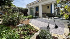 A house with a patio area, a barbecue grill, and a garden with various plants. - House for 4 with Wifi near the beach in Dolus-d'Oléron (Dolus-d'Oléron)