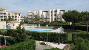 A residential complex with a swimming pool surrounded by greenery and a clear sky. - Saint-Cyprien: Renovated T2 cabin for 6, pool, parking, 100m from the beach (Saint-Cyprien)