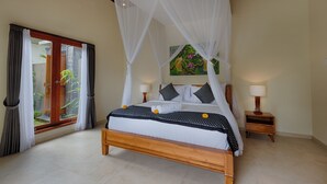 A bedroom with a wooden bed, white canopy, two bedside tables with lamps, and a view of a garden through a glass door. - Kelusa Hill (Payangan)
