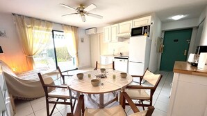 A compact kitchen with white cabinets, a microwave, and a refrigerator.