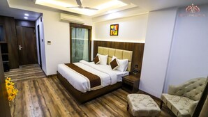 Habitació d'hotel moderna amb un llit gran, una tauleta de nit, una cadira i un ventilador de sostre.
