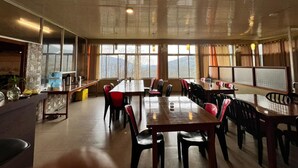 Una àmplia zona de dinar amb sostres alts i grans finestres que ofereixen vista a les muntanyes.