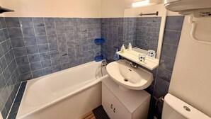 Ein Badezimmer mit Badewanne, Waschbecken und Spiegel.