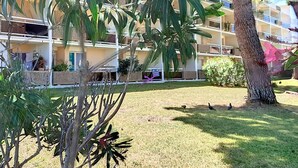 A multi-story building with balconies, surrounded by greenery and a grassy area. - Charming 1BR Apartment, Garden View, Near Beach & Shops, Parking Available (Bormes-les-Mimosas)