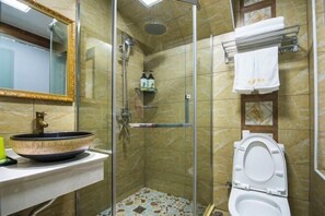 A bathroom with a glass-enclosed shower, a sink with a decorative bowl, a toilet, and a mirror with a gold frame. - Hongcun Summary Ruiyun Boutique Hotel (Yi County)