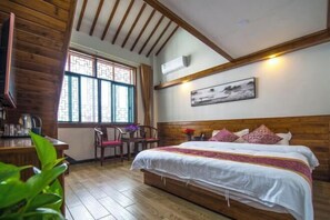 A room with a wooden ceiling, a bed with white bedding, a desk with a chair, and a window with patterned glass. - Hongcun Summary Ruiyun Boutique Hotel (Yi County)