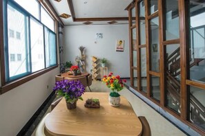 A room with a wooden table, potted plants, and a window with a view of the outside. - Hongcun Summary Ruiyun Boutique Hotel (Yi County)