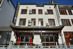 A traditional building with multiple floors, large windows, and a decorative entrance. - Hongcun Summary Ruiyun Boutique Hotel (Yi County)