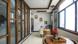 A modern interior with a wooden dining table, chairs, and a window with a view.