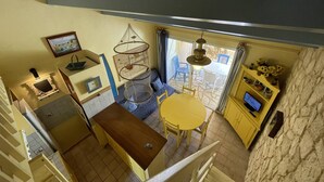 Una cucina compatta con zona pranzo, un lampadario e vista all'esterno.
