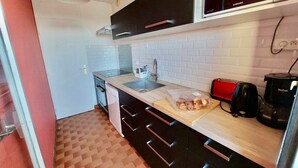 A compact kitchen with a wooden countertop, a sink, a toaster, and a coffee maker. - 2-room apartment with balcony and parking, 250m from the beach (La Grande-Motte)