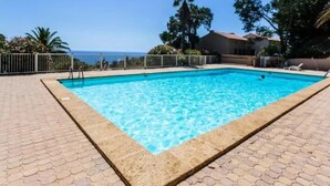 A rectangular swimming pool with clear blue water, surrounded by a paved deck and a metal fence. - Quiet apartment with pool and parking, near beach, for 4 people in Rayol-Canadel (Rayol-Canadel-sur-Mer)