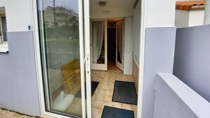 Un immeuble résidentiel doté d’une porte-fenêtre coulissante qui donne sur un couloir carrelé.