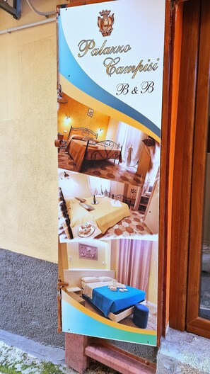 Ein Hotelschild mit Logo und Name, das ein Bed and Breakfast namens "Palazzo Campisi" anzeigt.