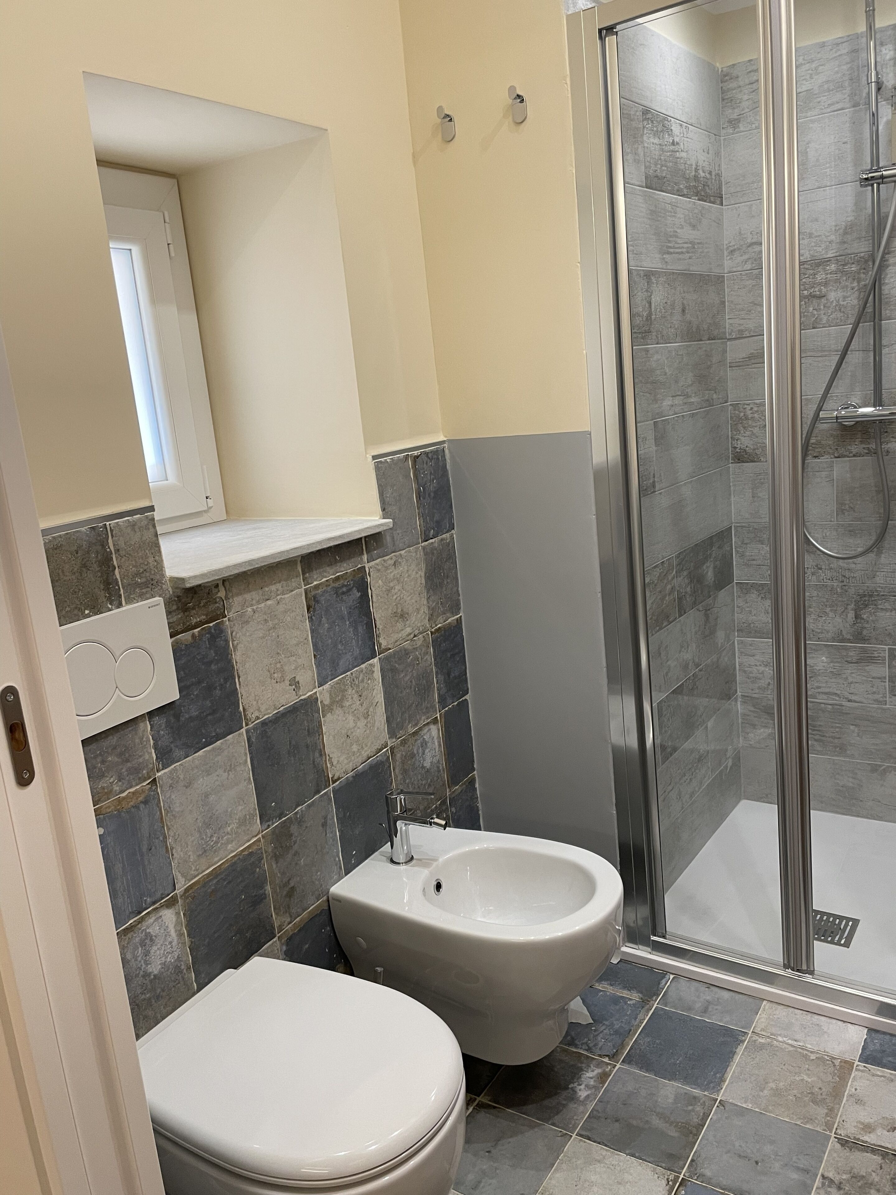 Een badkamer met toilet, bidet en douchehoek.