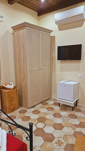 Ein Zimmer mit Kleiderschrank, Fernseher und Kaffeemaschine.