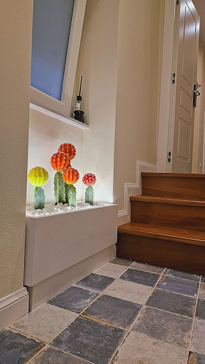 A staircase with a decorative glass display featuring cacti and a small sculpture. - B&B Palazzo campisi (Tropea)