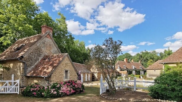 A stone building with a sloped roof, surrounded by greenery and a white fence. - Charming Countryside Retreat: Heated Pool, Tennis, Games Room - Near Le Mans (Maresché)