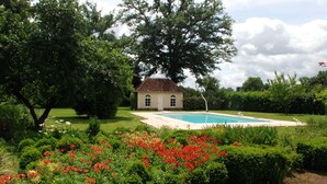 A house with a swimming pool, surrounded by well-maintained gardens and trees. - Charming Countryside Retreat: Heated Pool, Tennis, Games Room - Near Le Mans (Maresché)