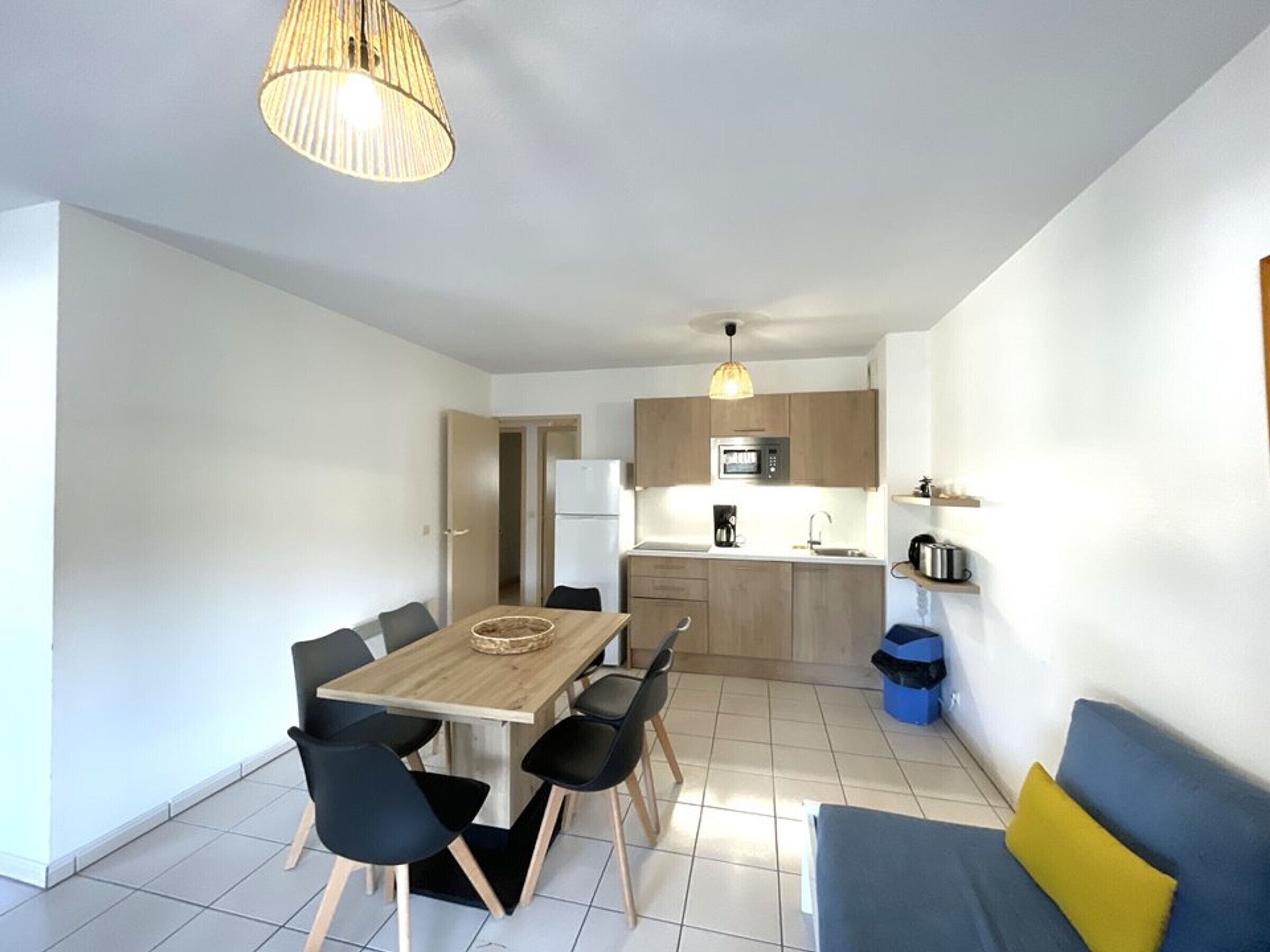 A modern apartment with a dining area, kitchen, and living space.