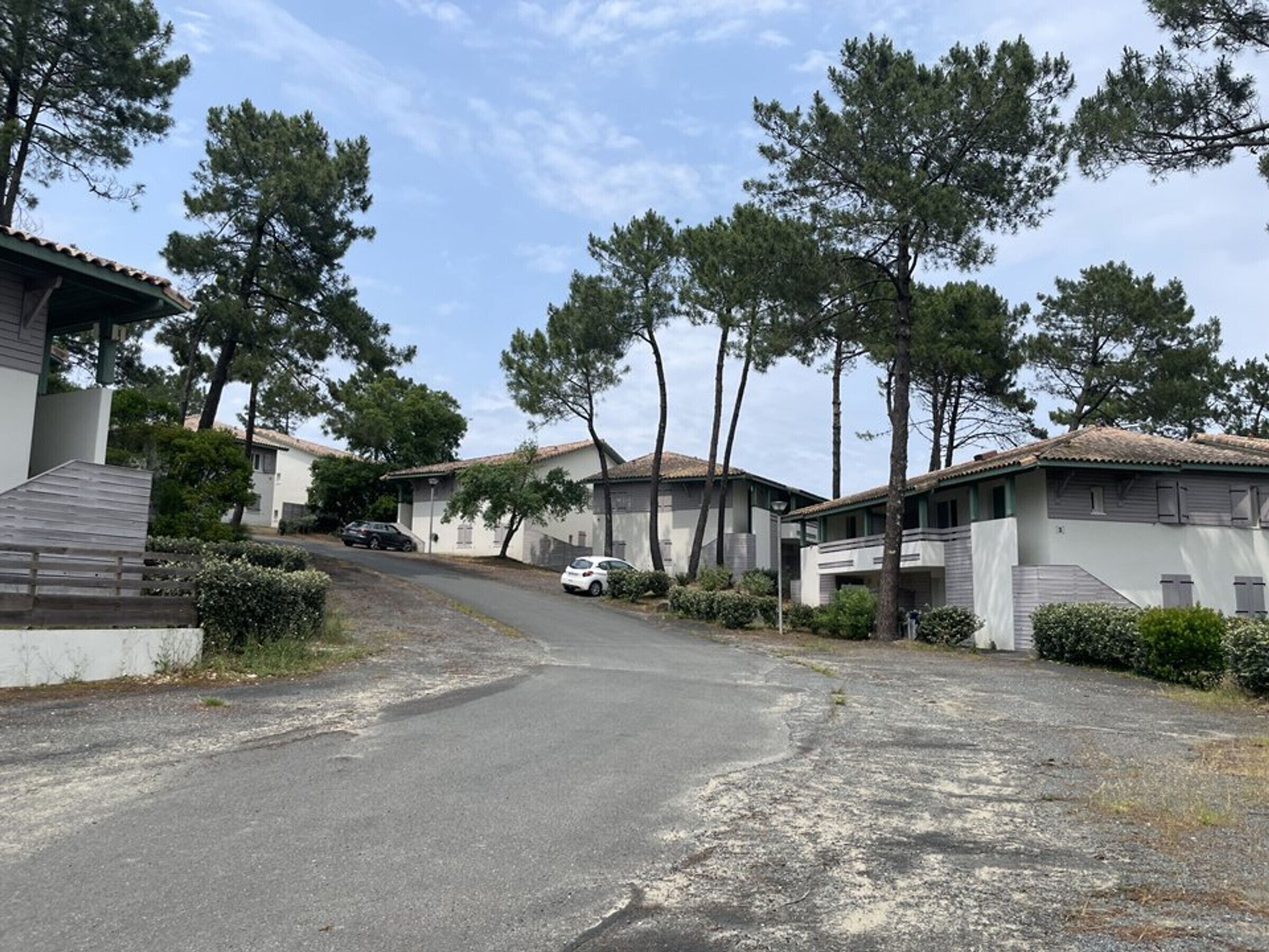 Quartiere residenziale con case, strada asfaltata e auto parcheggiate.