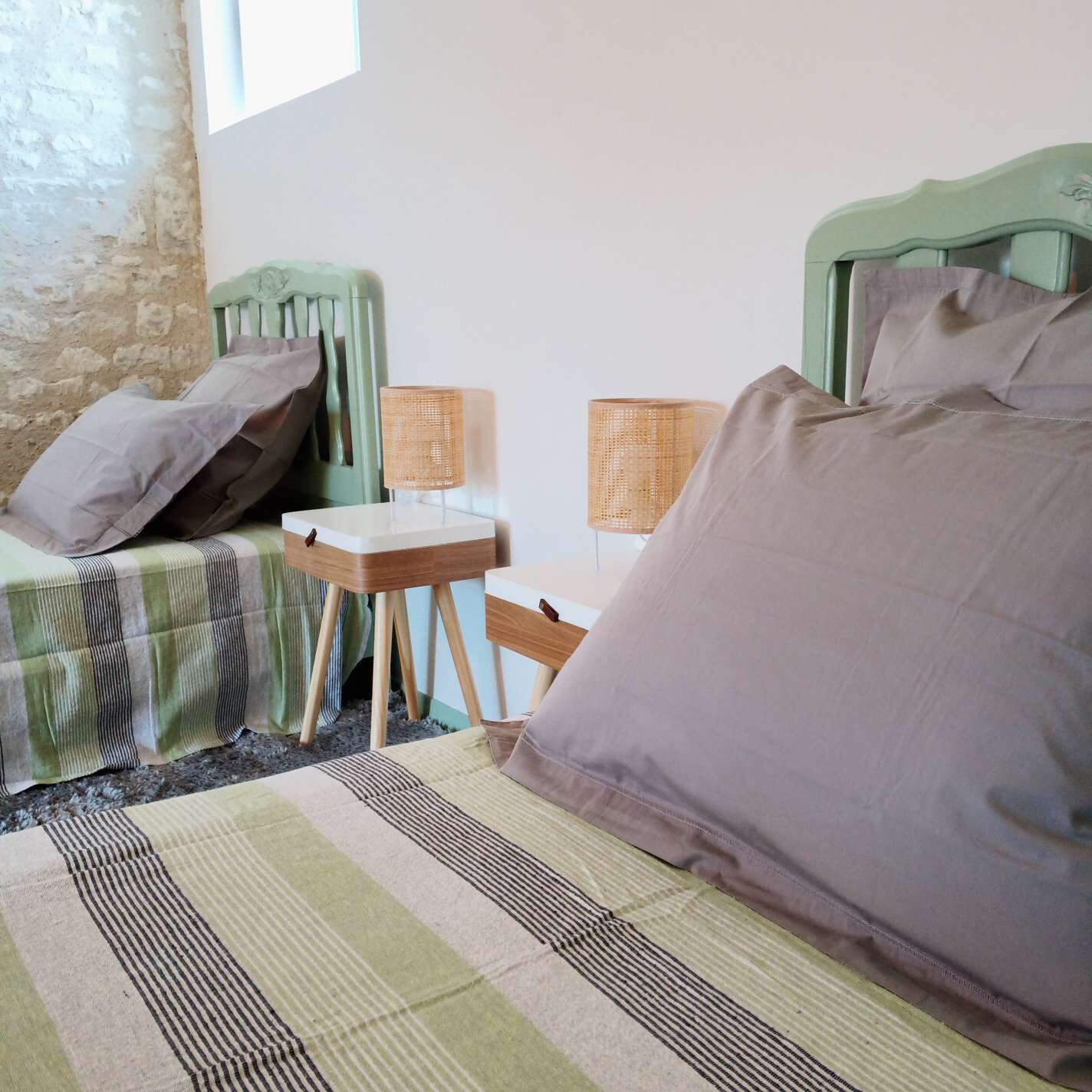 Una habitación con dos camas, una mesita y dos lámparas.