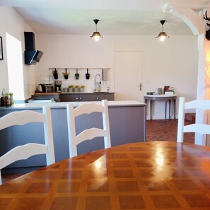 A modern kitchen with white cabinetry, a central island, and pendant lighting. - At the elves' rest. "Le grand chevreuil au nez vert", 3* B&B in Richelieu (Braye-Sous-Faye)