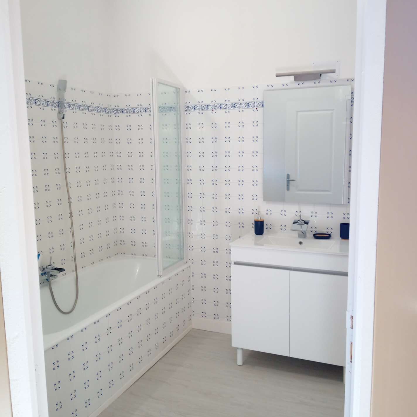 Un baño con ducha, lavabo y espejo.