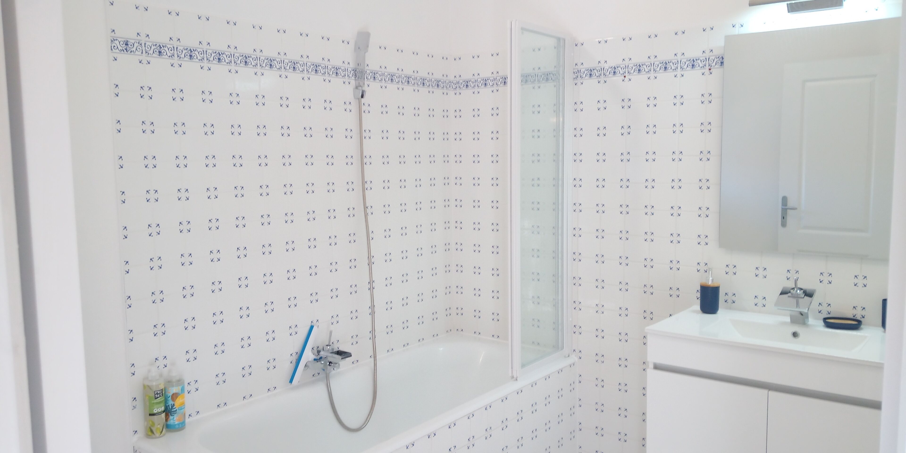 A bathroom with a bathtub, a shower, a sink, and a mirror.