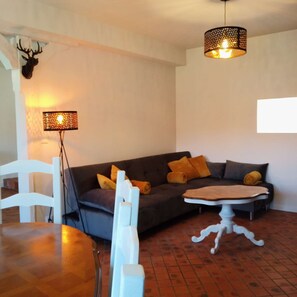 A living room with a dark sofa, white chairs, a small table, and a floor lamp. - At the elves' rest. "Le grand chevreuil au nez vert", 3* B&B in Richelieu (Braye-Sous-Faye)